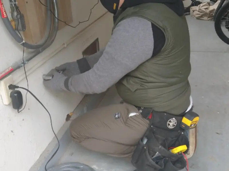 Electrician performing outlet wiring in a Lutherville garage